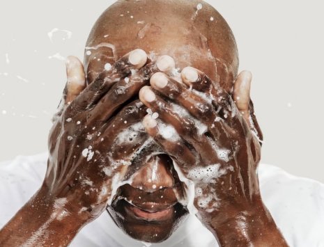 Mann vasker ansikt med såpe