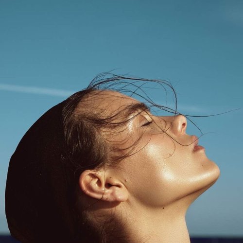 Kvinneansikt i profil mot blå himmel