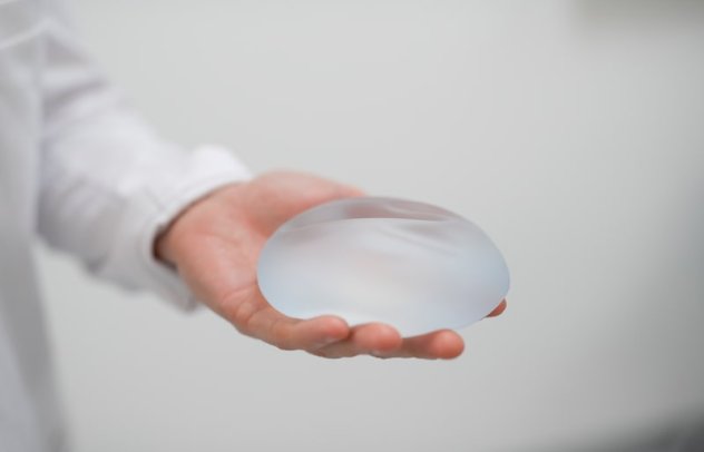 Plastikkirurg hos Asteta Clinic viser frem en silikonprotese