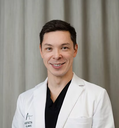Dr. Kenneth Chiu fra Asteta Clinic, iført hvit frakk foran et nøytralt bakteppe.