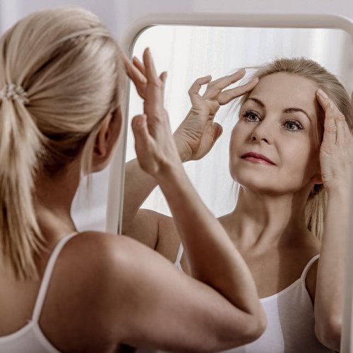 Kvinne ser på panne og hårfeste i speilet
