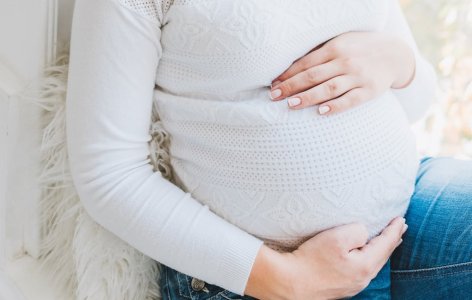 Gravid kvinne holder rundt magen