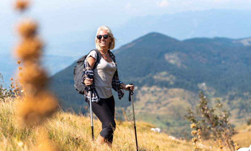 Kvinne på fjelltur med gåstaver