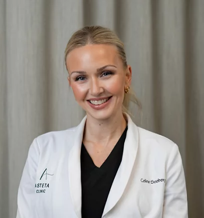 Kosmetisk dermatologisk sykepleier Celine fra Asteta Clinic, iført hvit frakk og smilende foran et nøytralt bakteppe.