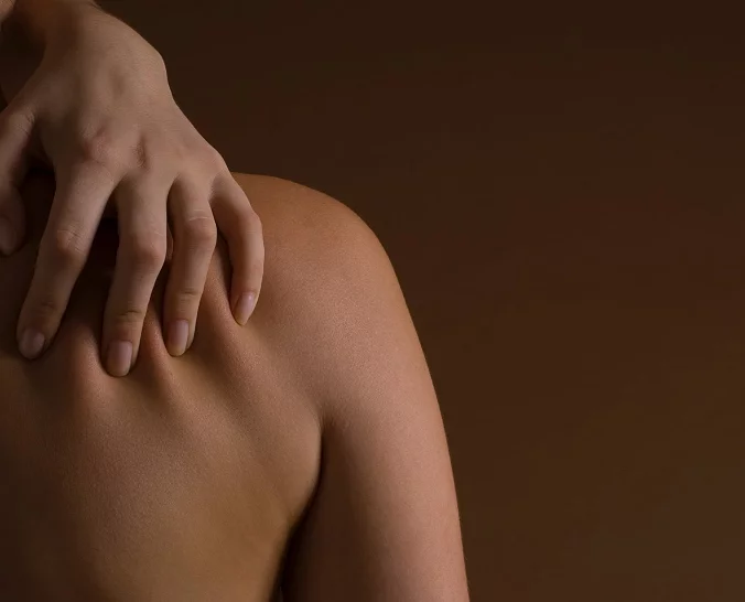 Kvinnelig modell for Asteta Clinic med hånd på ryggen